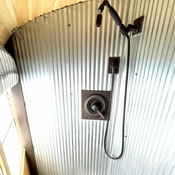 metal corrugated shower in a skoolie