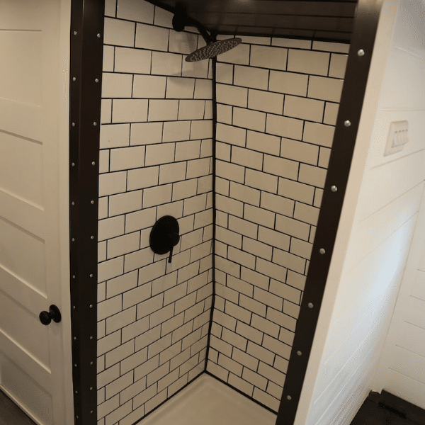 white subway tile dark grout skoolie shower